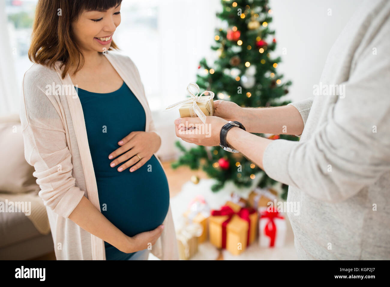 husband giving christmas present to pregnant wife Stock Photo - Alamy