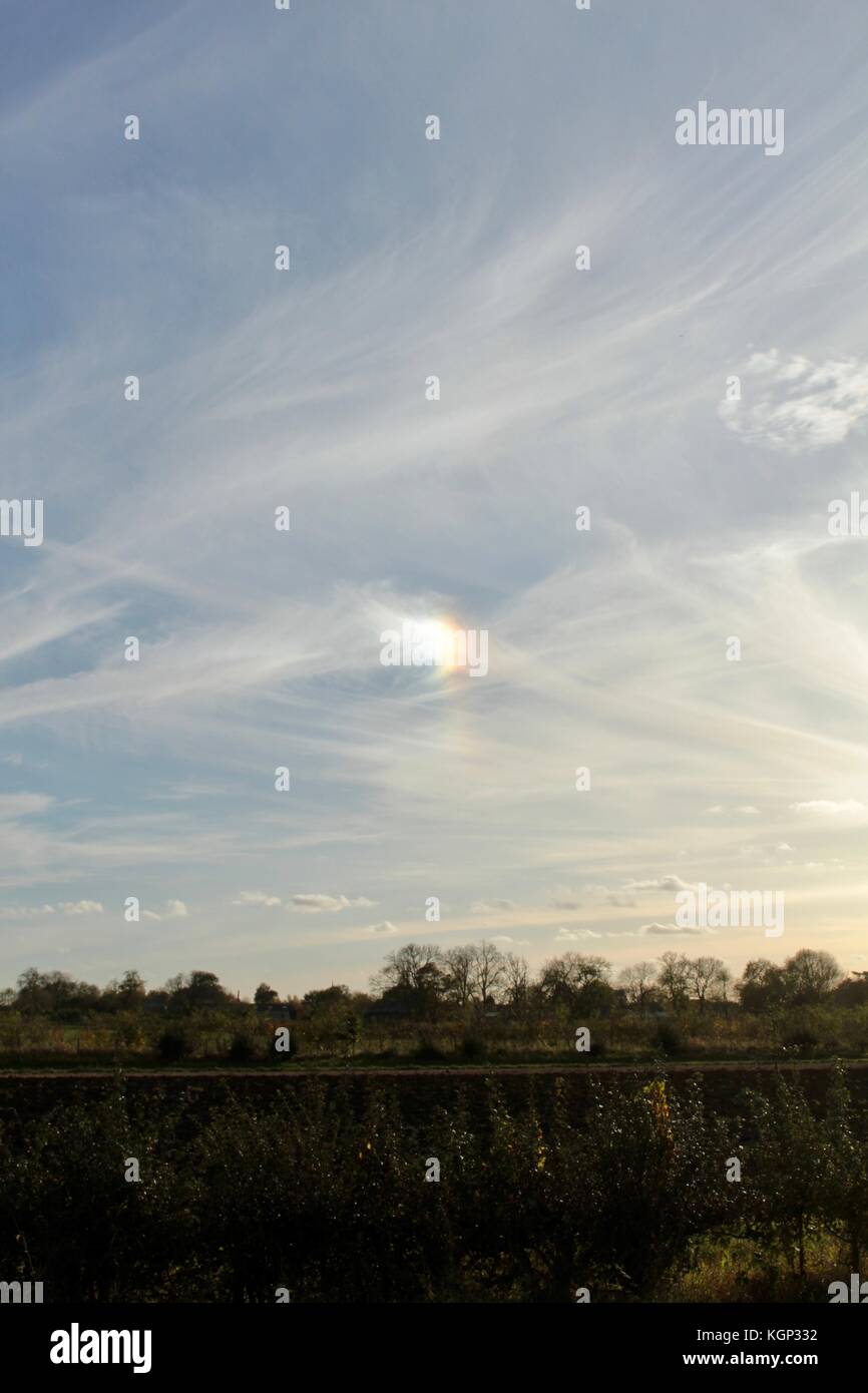 Mini rainbow, or sundog, in the middle of lightly cloudy sky late afternoon in Fen Drayton Lakes, Cambidgeshire Stock Photo