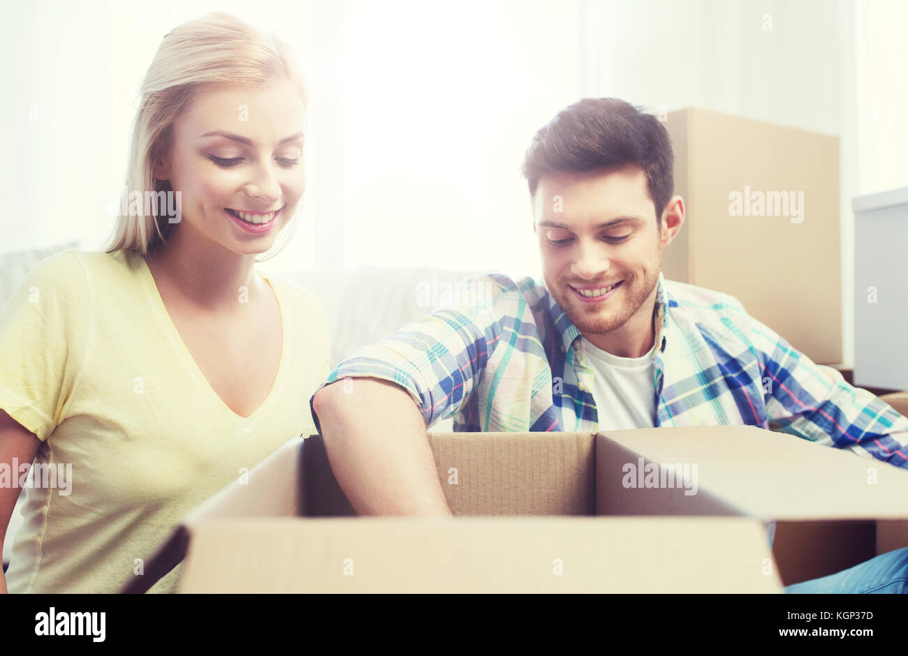 smiling couple with big boxes moving to new home Stock Photo - Alamy