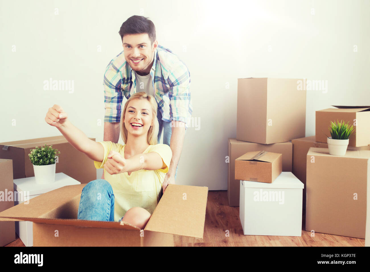 happy couple having fun with boxes at new home Stock Photo - Alamy