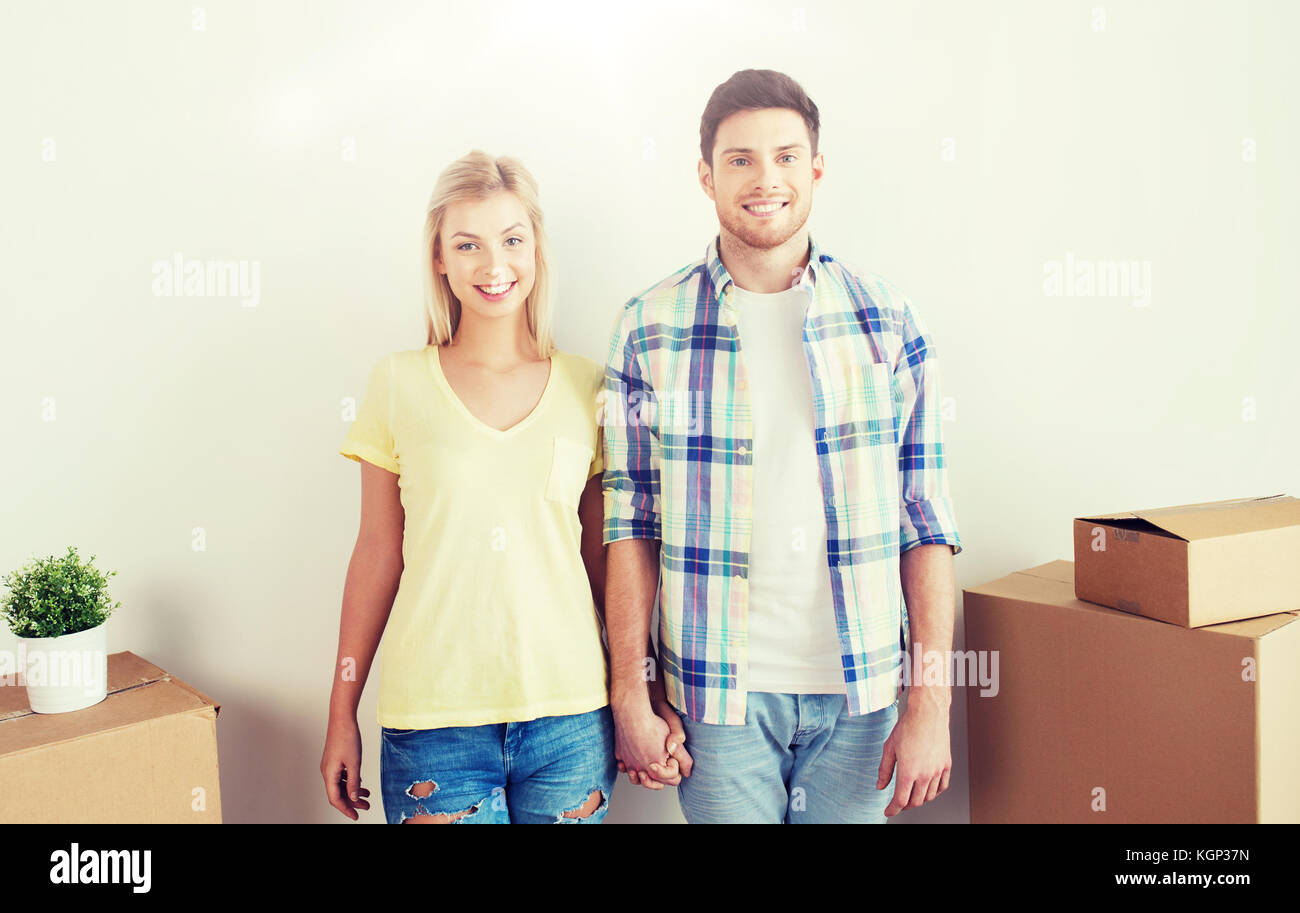 smiling couple with big boxes moving to new home Stock Photo - Alamy