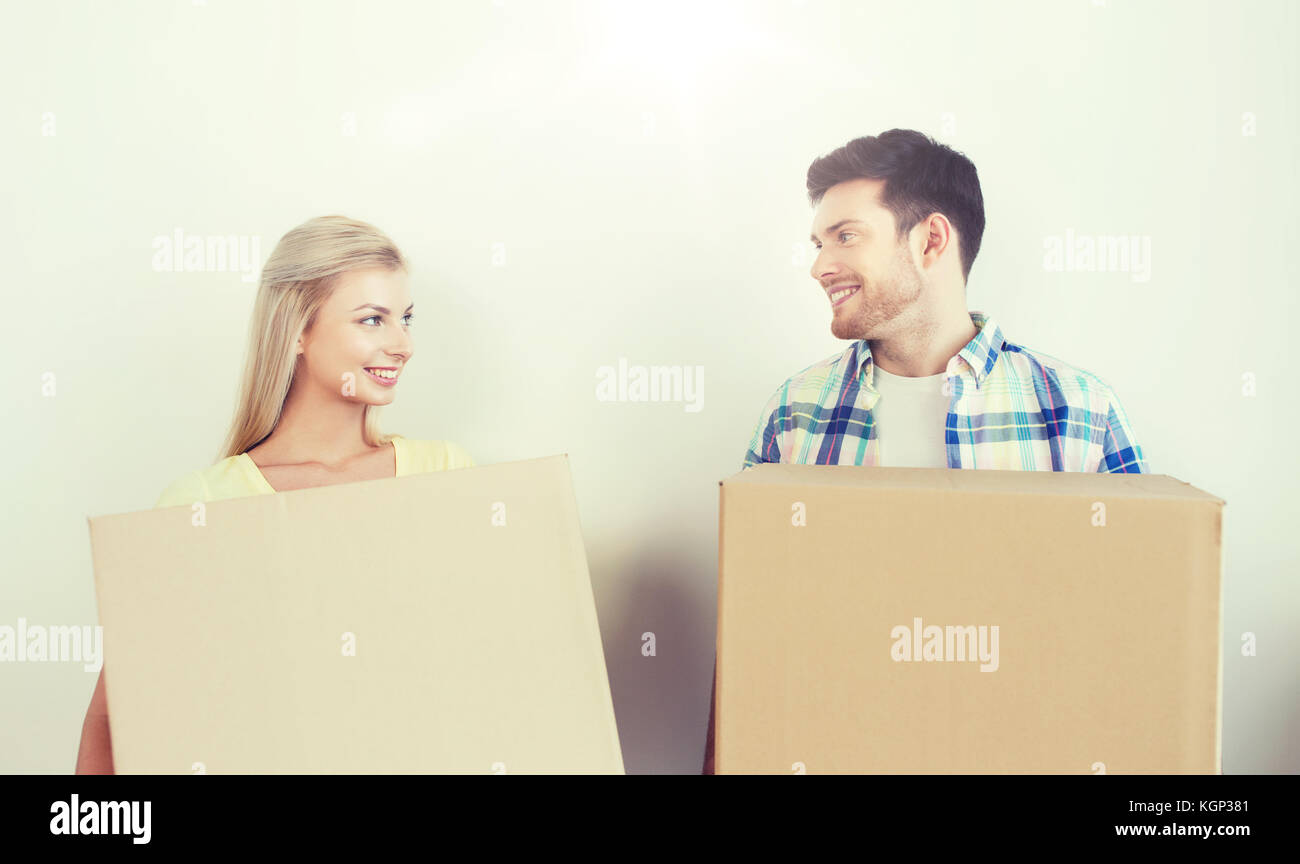 smiling couple with big boxes moving to new home Stock Photo - Alamy