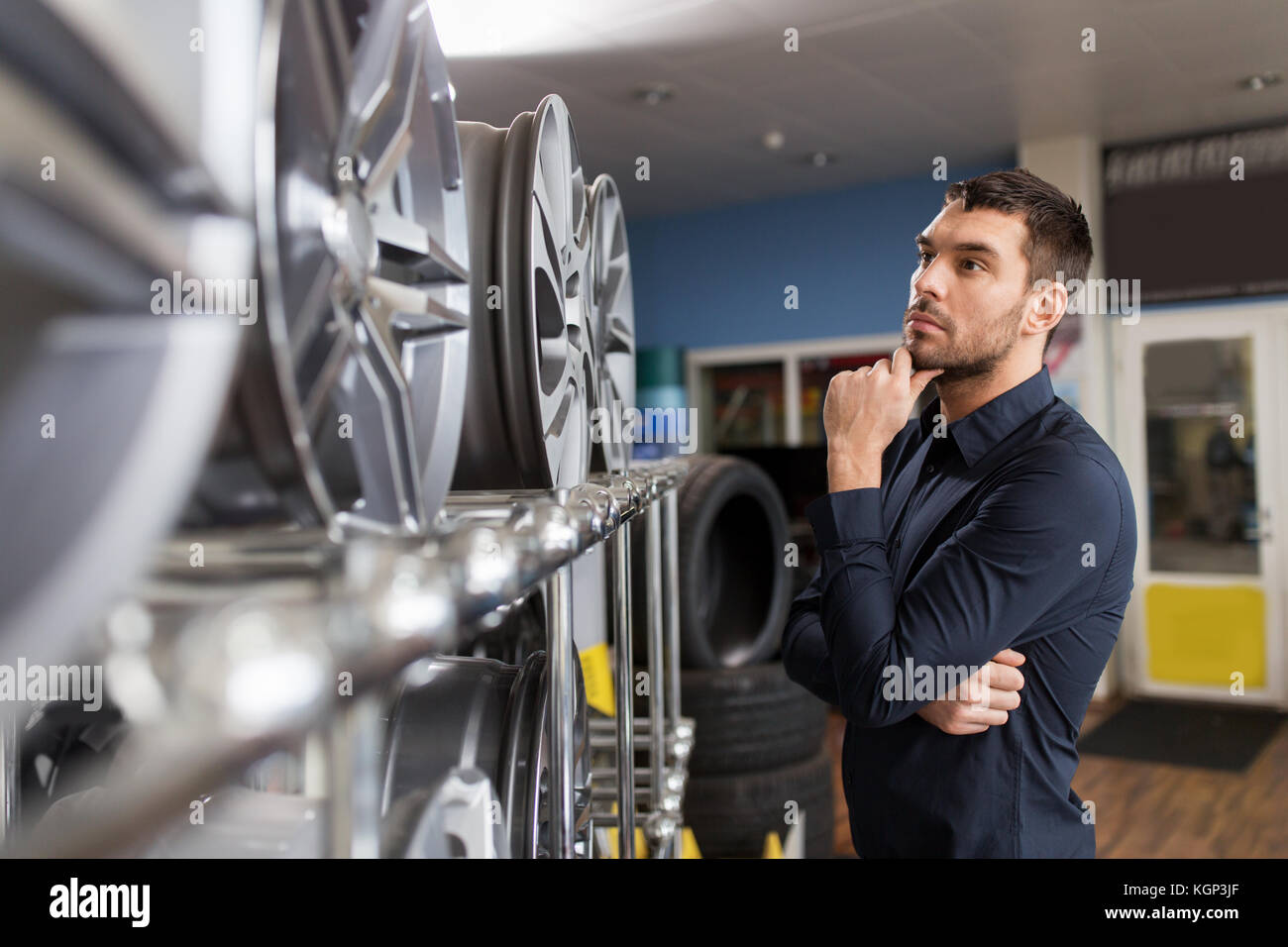 male customer choosing wheel rims at car service Stock Photo Alamy
