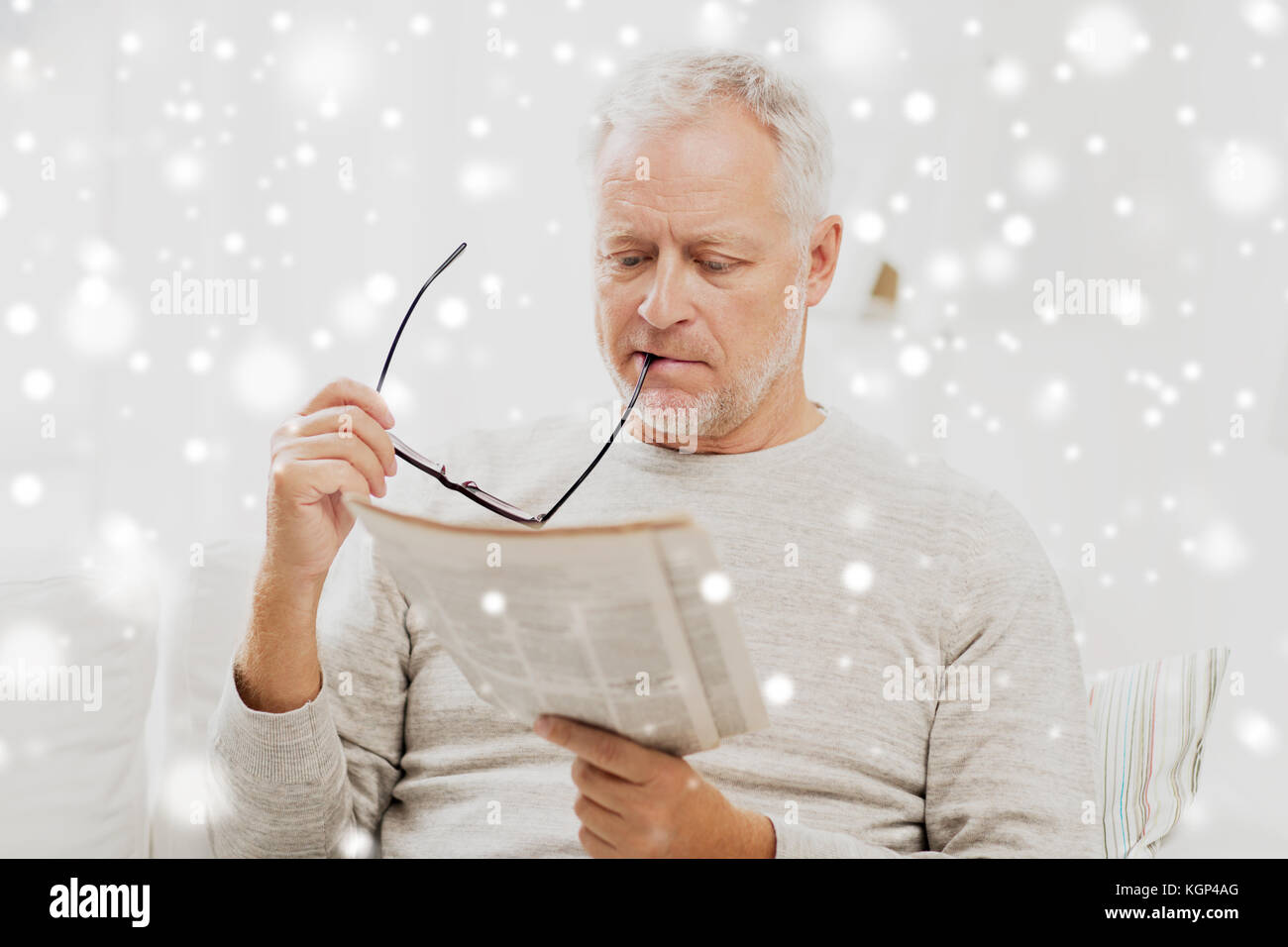 senior man in glasses reading newspaper at home Stock Photo