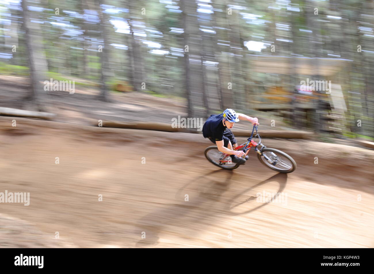 Mountain biking at Chicksands, Bedfordshire. Riders descending down a steep track littered with jumps and berms. Stock Photo