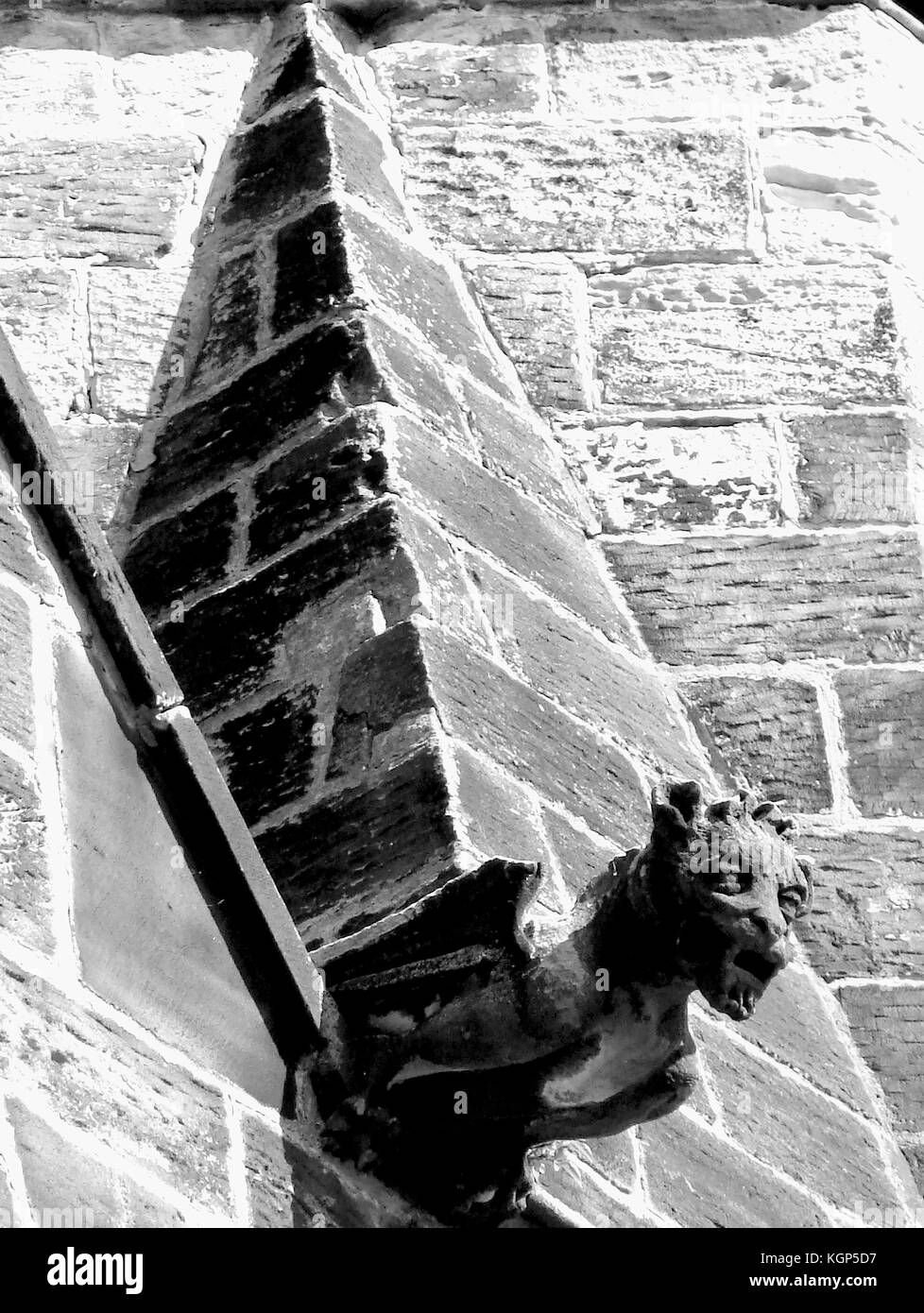 Church symbolism - winged  lion ( the evangelist St Mark)  gargoyle & pyramid (integration of self-and soul) on a Whitby Roman Catholic church. Stock Photo