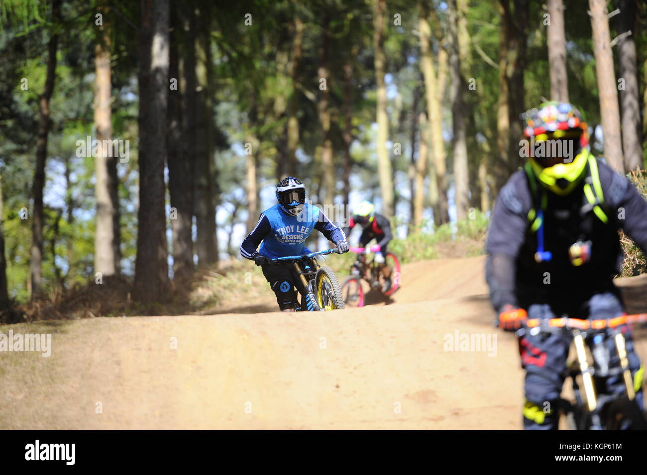 Mountain biking at Chicksands, Bedfordshire. Riders descending down a steep track littered with jumps and berms. Stock Photo