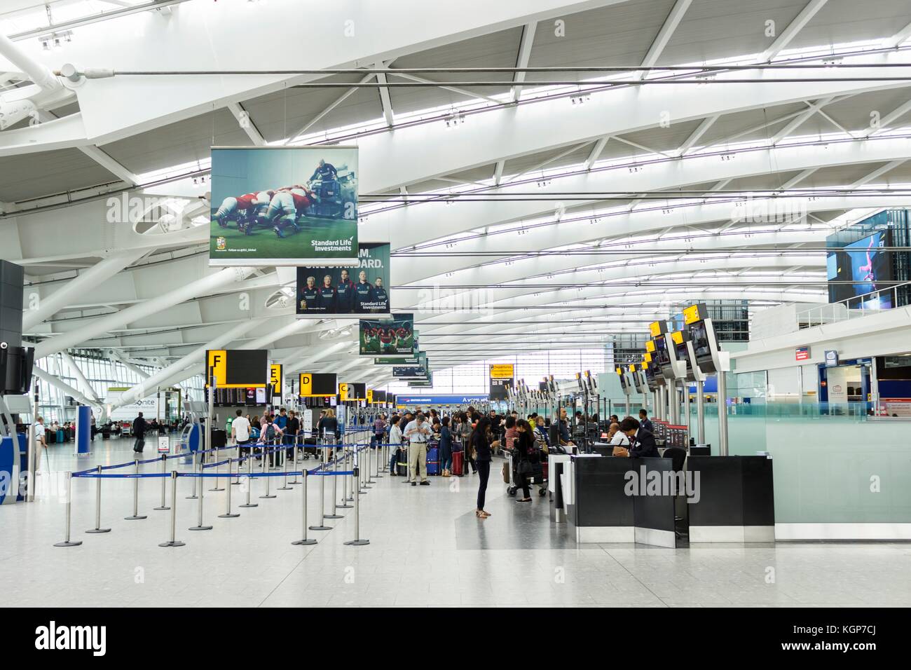 Passengers queue for check in at the departure hall in Terminal 5, Heathrow Airport Stock Photo