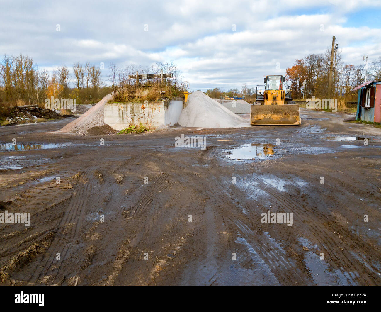 Wheel bulldozer with rotary u-blade and bucket on construction of road. Heavy machine equipment for excavation works at civil industrial construction. Stock Photo