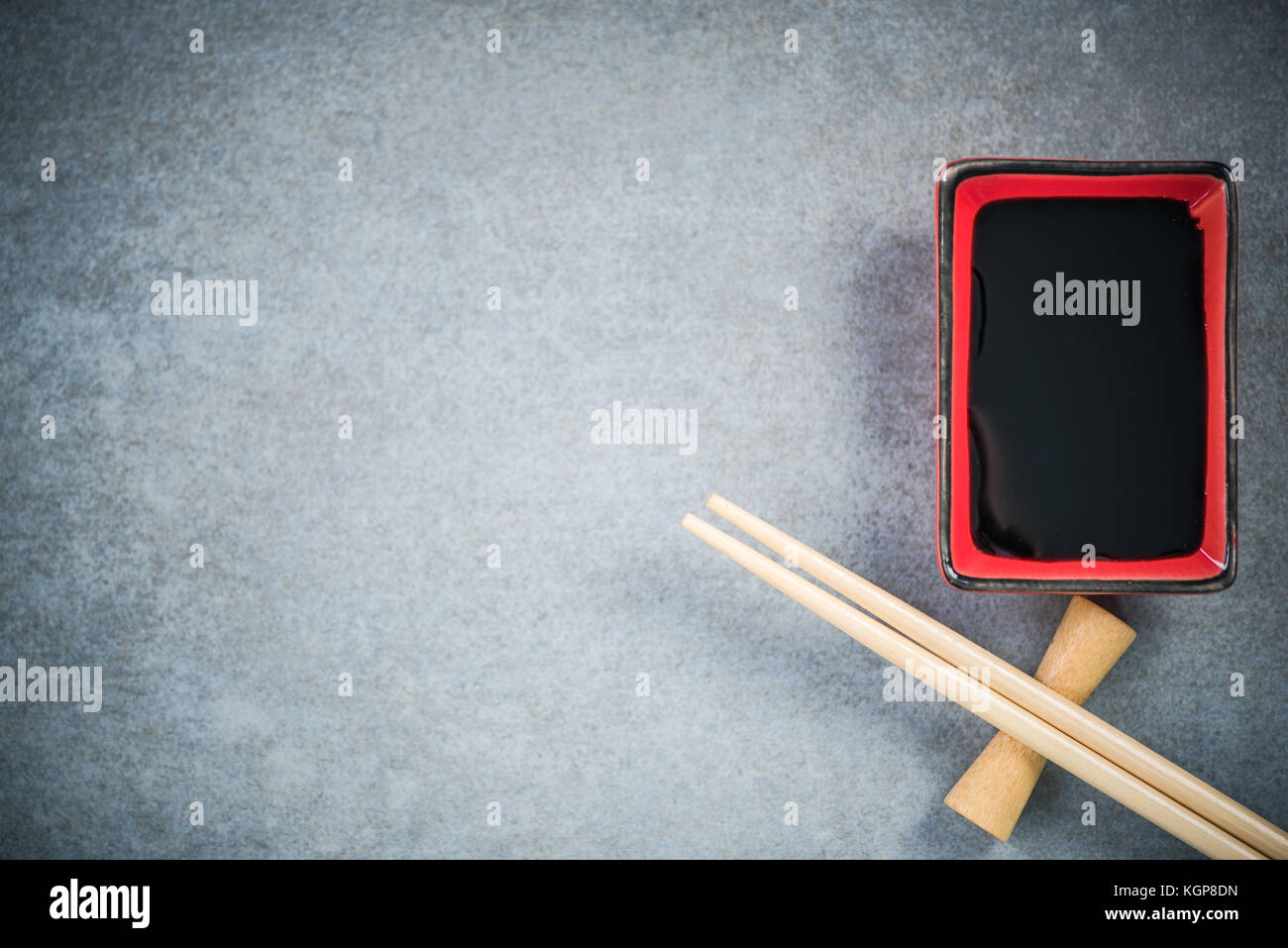Chopsticks and soy sauce on stone concrete board. Stock Photo