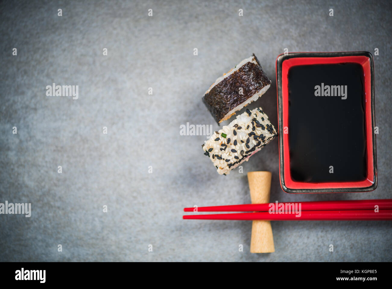 Chopsticks and soy sauce on stone concrete board. Stock Photo