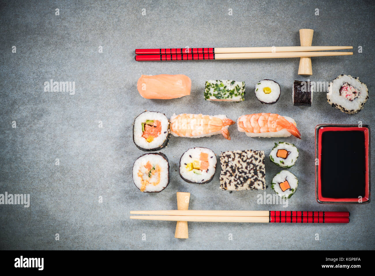 Sushi on stone or concrete slate with chopsticks. Stock Photo