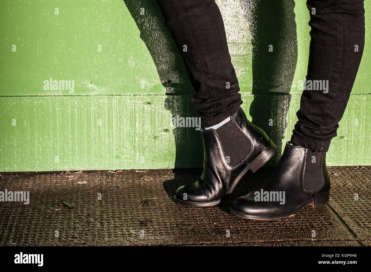 Model wearing black trousers and ladies vintage boots with low heel (short Chelsea ankle) on the street Stock Photo