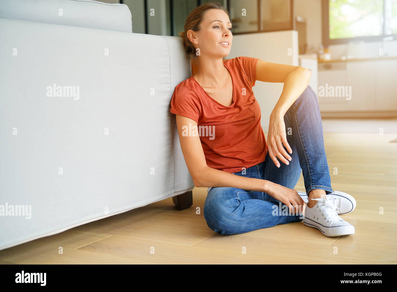 Woman sitting on wooden floor, relaxed Stock Photo - Alamy