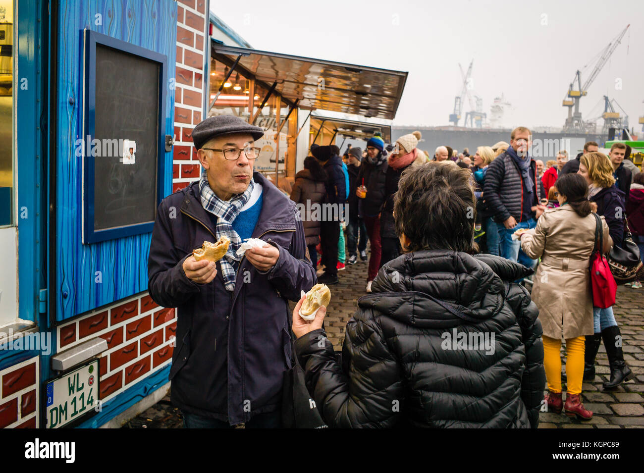 A couple enjoy a breakfast roll from a stall at the Fischmarkt in Hamburg, Germany. Stock Photo