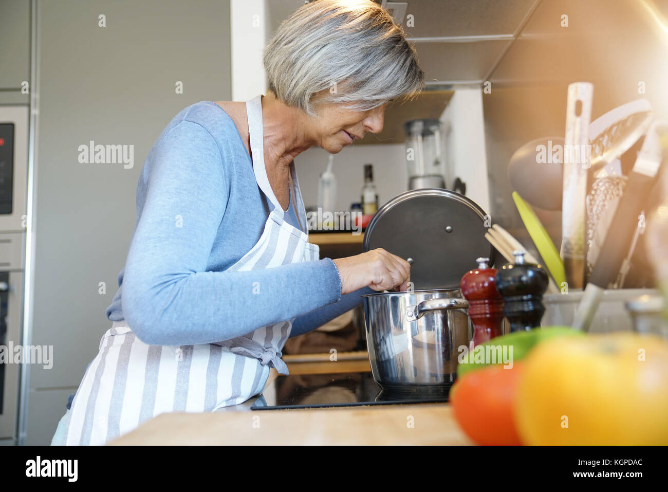 Senior woman in home kitchen cooking for dinner Stock Photo