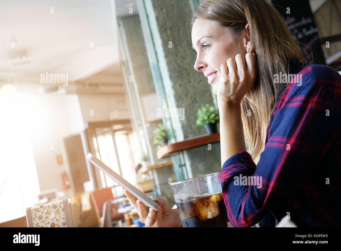 Cheerful woman in coffee shop using digital tablet Stock Photo