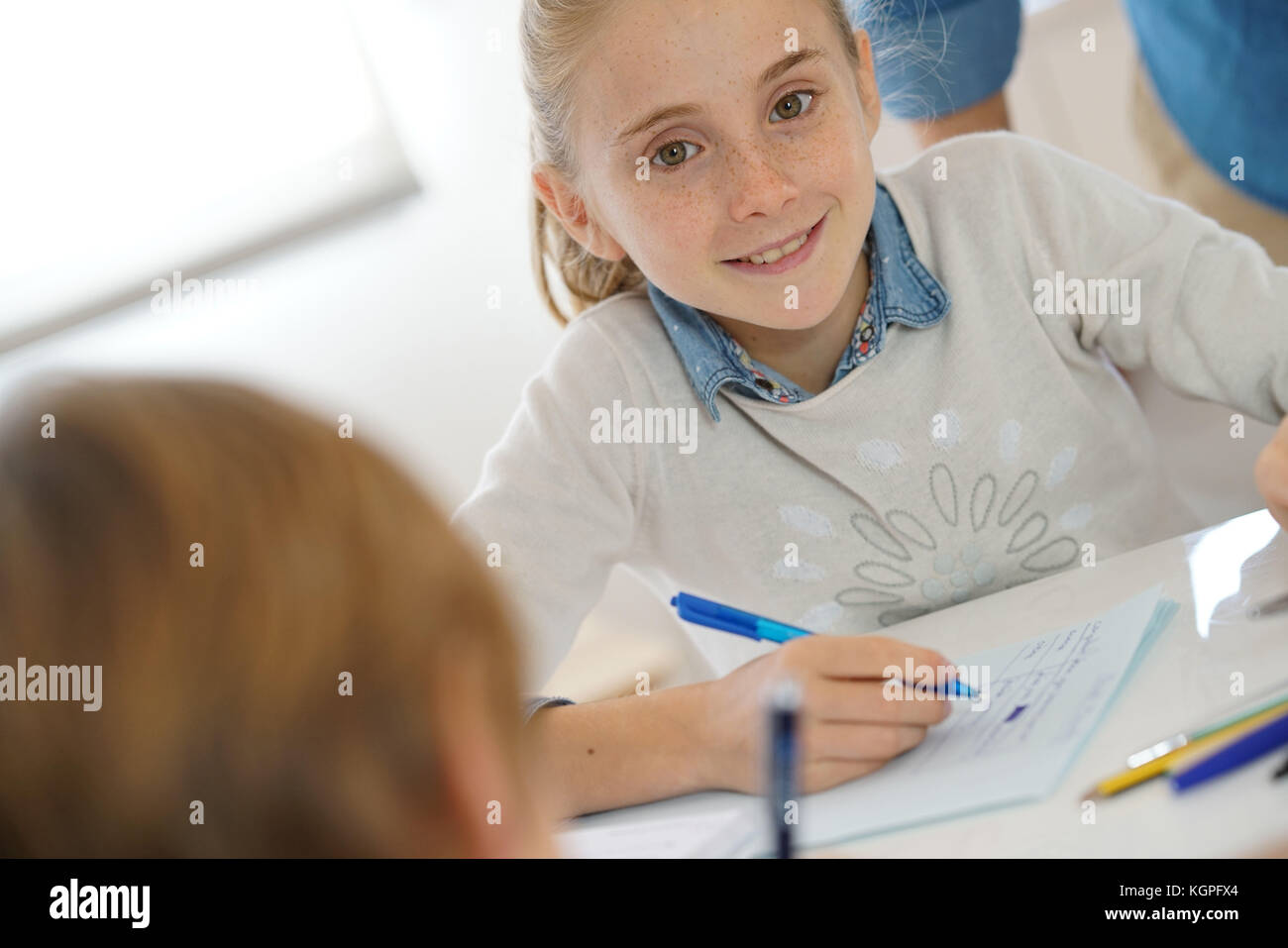 Portrait of school girl taking notes in class Stock Photo - Alamy