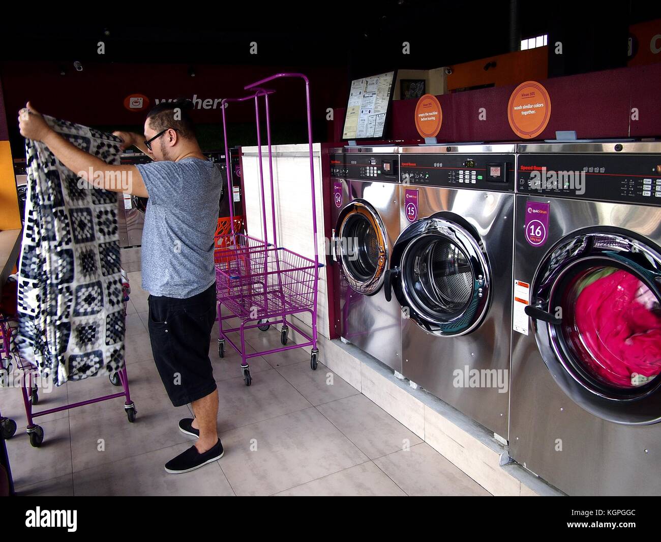 ANTIPOLO CITY, PHILIPPINES - NOVEMBER 7, 2017: A customer inside a newly established laundromat in the city of Antipolo in the Philippines. Stock Photo