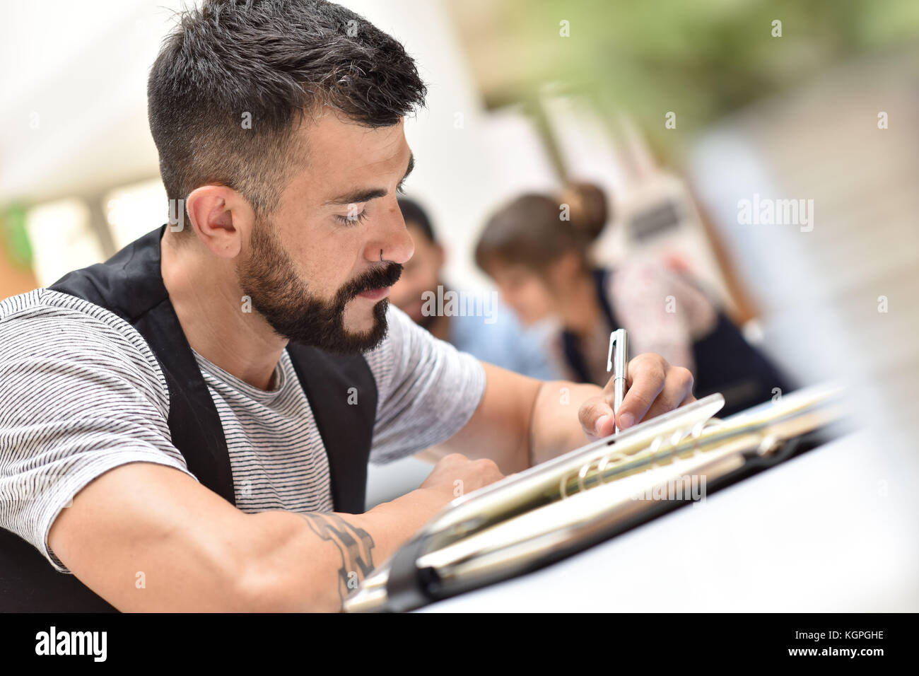 Trendy businessman in office working on tablet Stock Photo