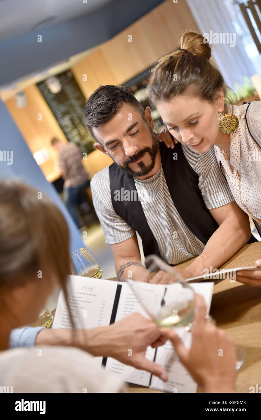Young trendy people in restaurant looking at menu Stock Photo - Alamy