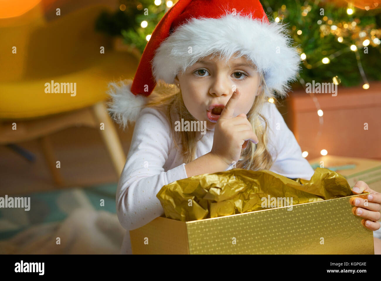 Portrait of cute little girl keeping a secret on Christmas eve Stock Photo