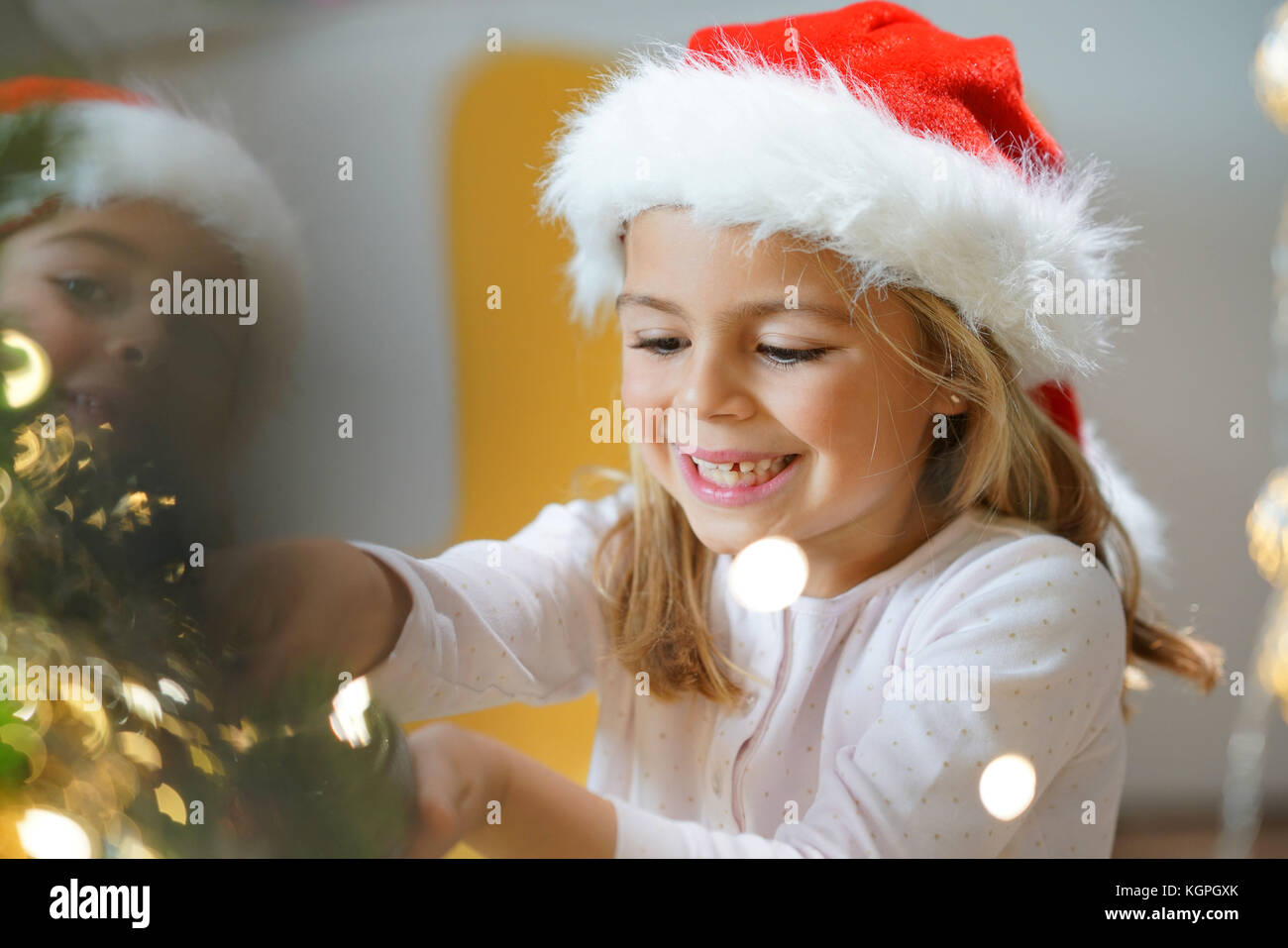 Portrait of cute little girl decorating Christmas tree Stock Photo - Alamy