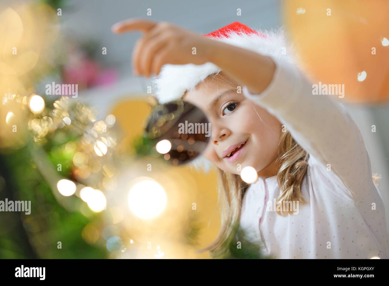 Portrait of cute little girl decorating Christmas tree Stock Photo - Alamy