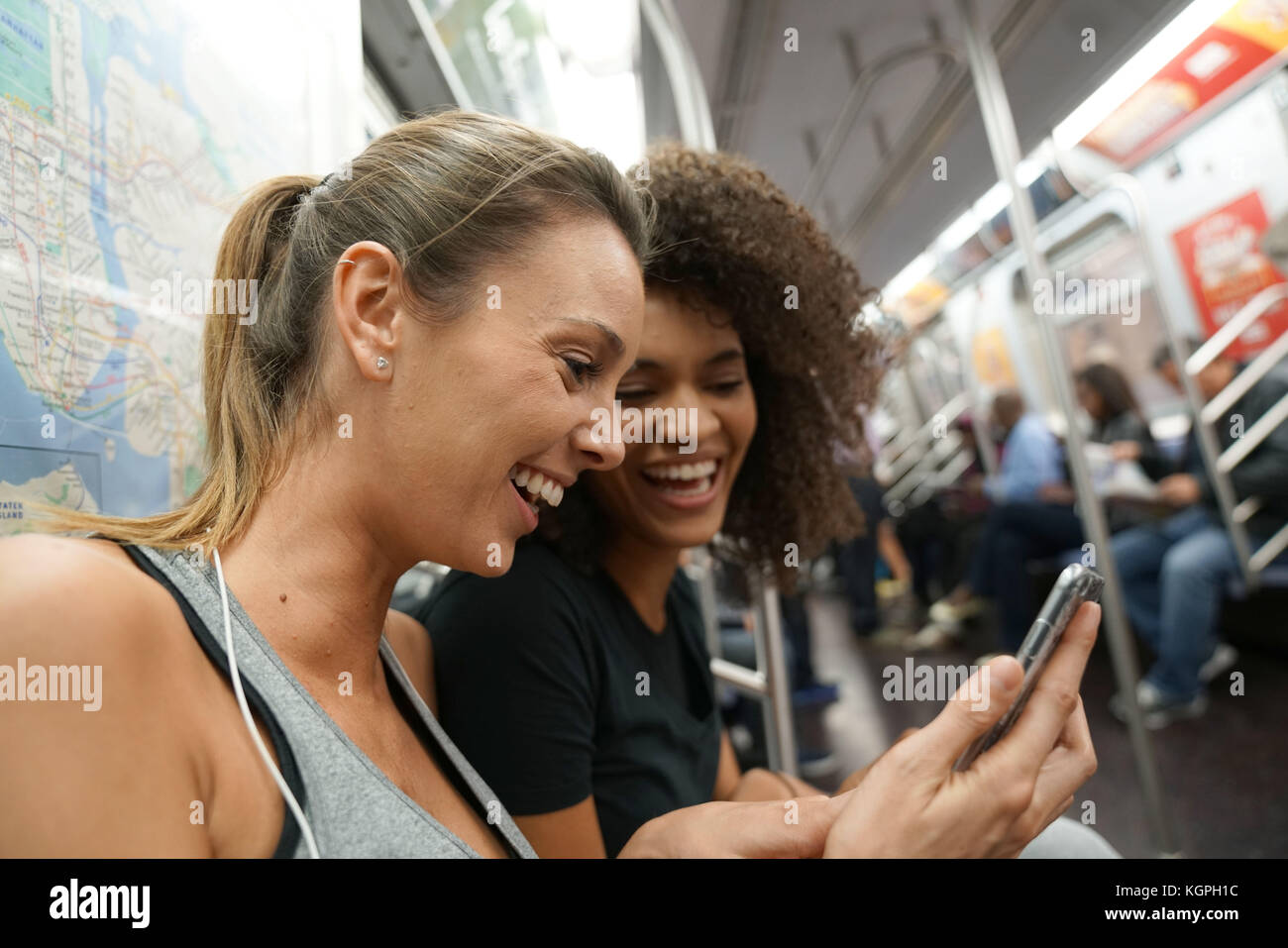 Girls in metro train using smartphone Stock Photo Alamy