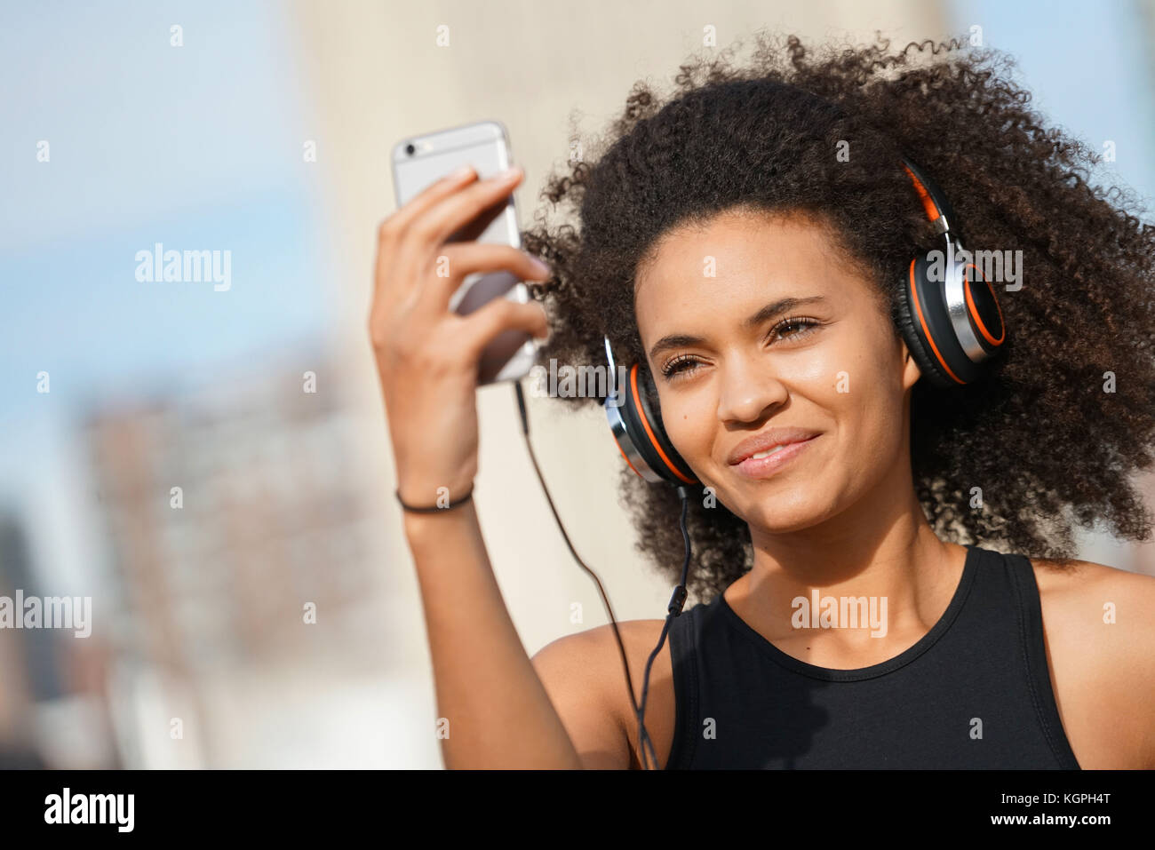 Fitness girl using smartphone and headset on jogging day Stock Photo - Alamy