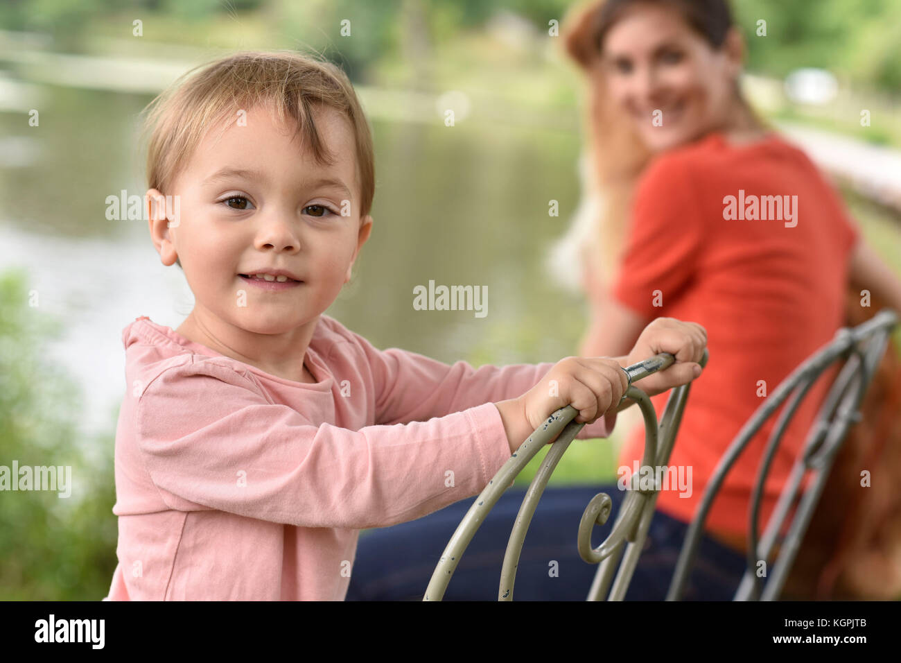 Portrait of little girl sitting on chair at the park Stock Photo - Alamy