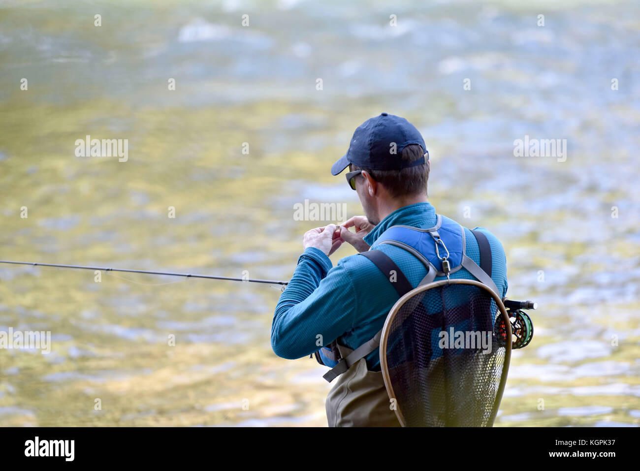 Fly-fisherman preparing fishing rod Stock Photo