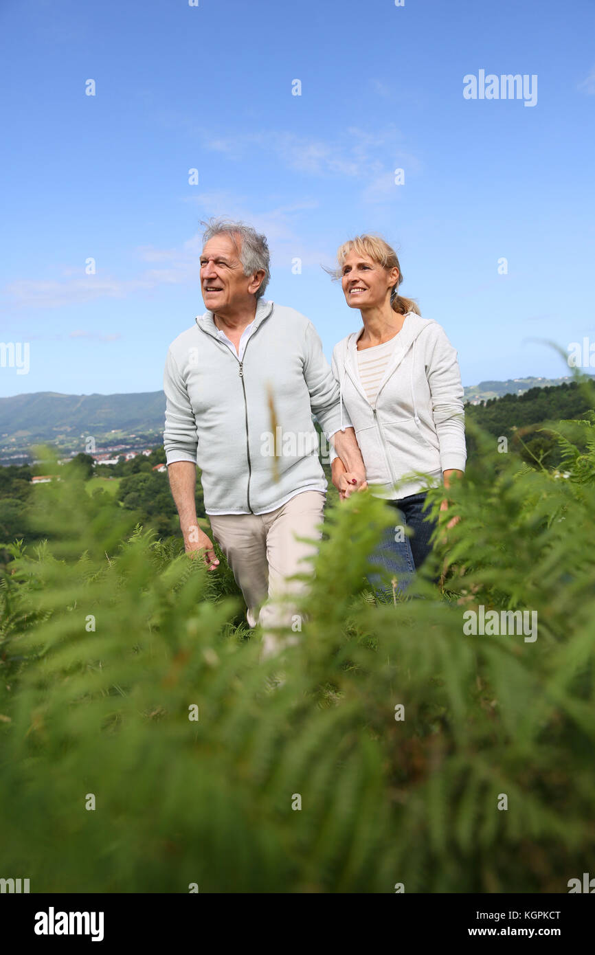 Senior couple walking in countryside, scenery Stock Photo