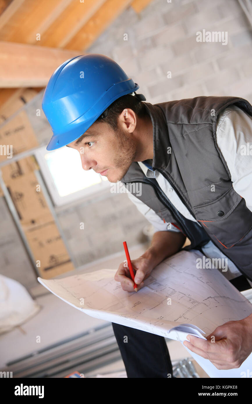 Construction manager on site reading blueprint Stock Photo