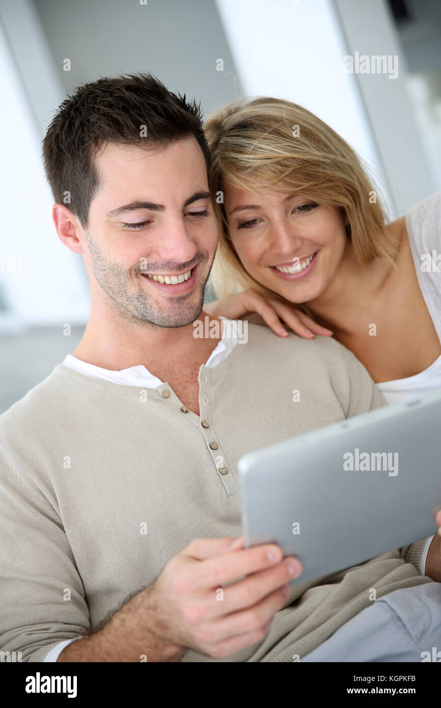 Cheerful couple using digital tablet at home Stock Photo - Alamy