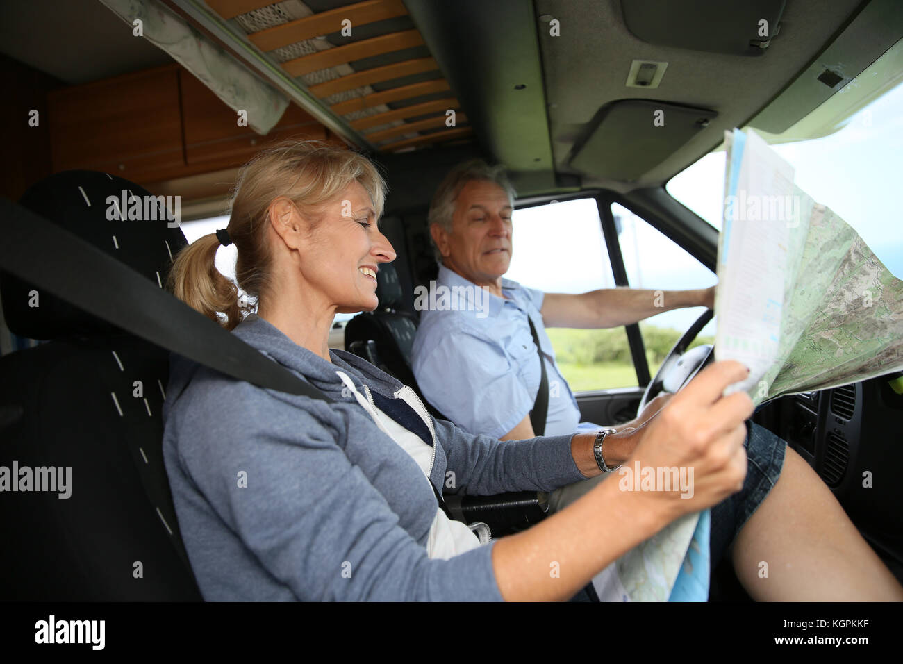 Senior couple riding camper and reading road map Stock Photo