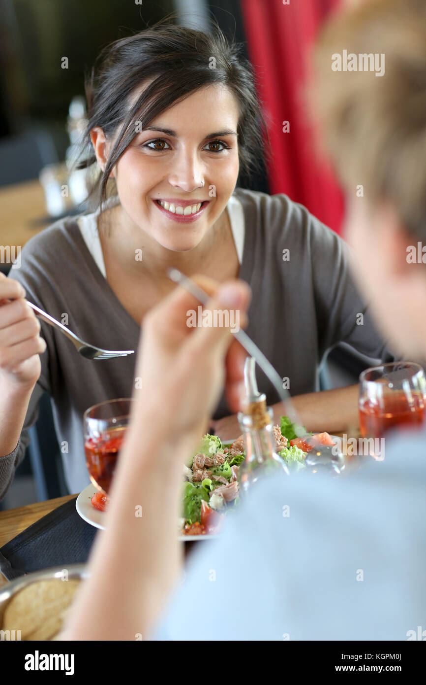 Young woman in restaurant eating lunch with boyfriend Stock Photo