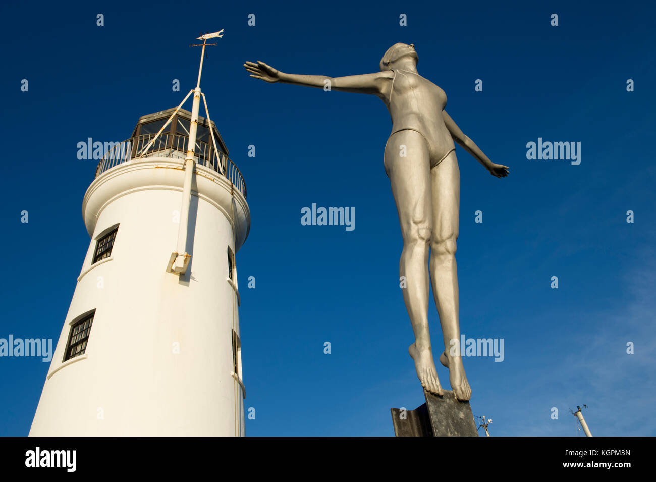 The Diving Belle statue and lighthouse located on the harbour in the North Yorkshire seaside town of Scarborough Stock Photo