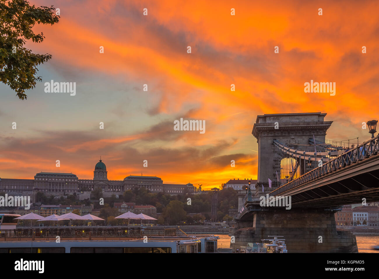 Budapest, Hungary - Beautiful dramatic golden sunset at Szechenyi Chain Bridge with Buda Castle Royal Palace at background Stock Photo