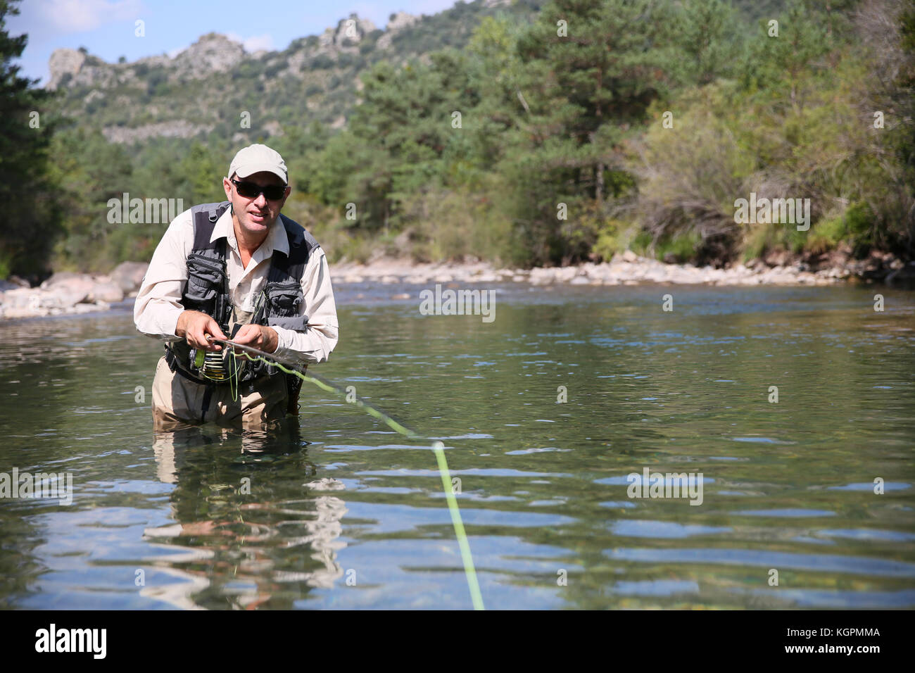 Closeup of fisherman fly fishing in freshwater river Stock Photo