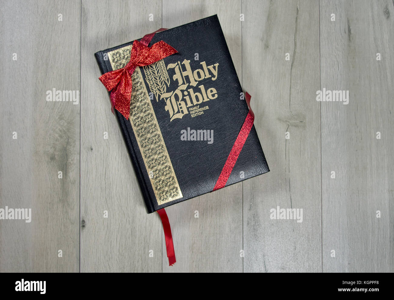 Holy Bible wrapped in red ribbon and bow as a Christmas gift Stock Photo