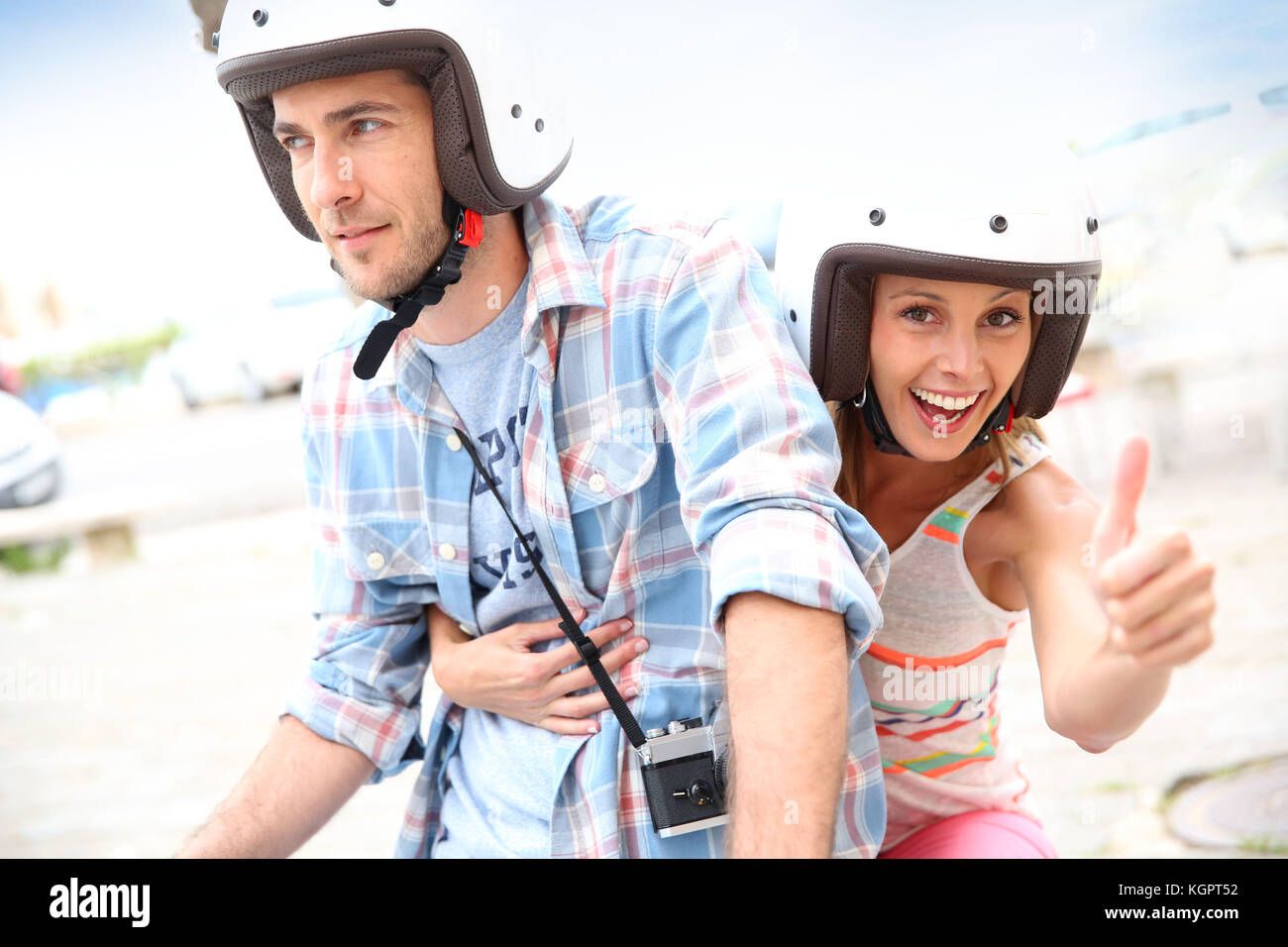 Girl riding moto with boyfriend and showing thumb up Stock Photo