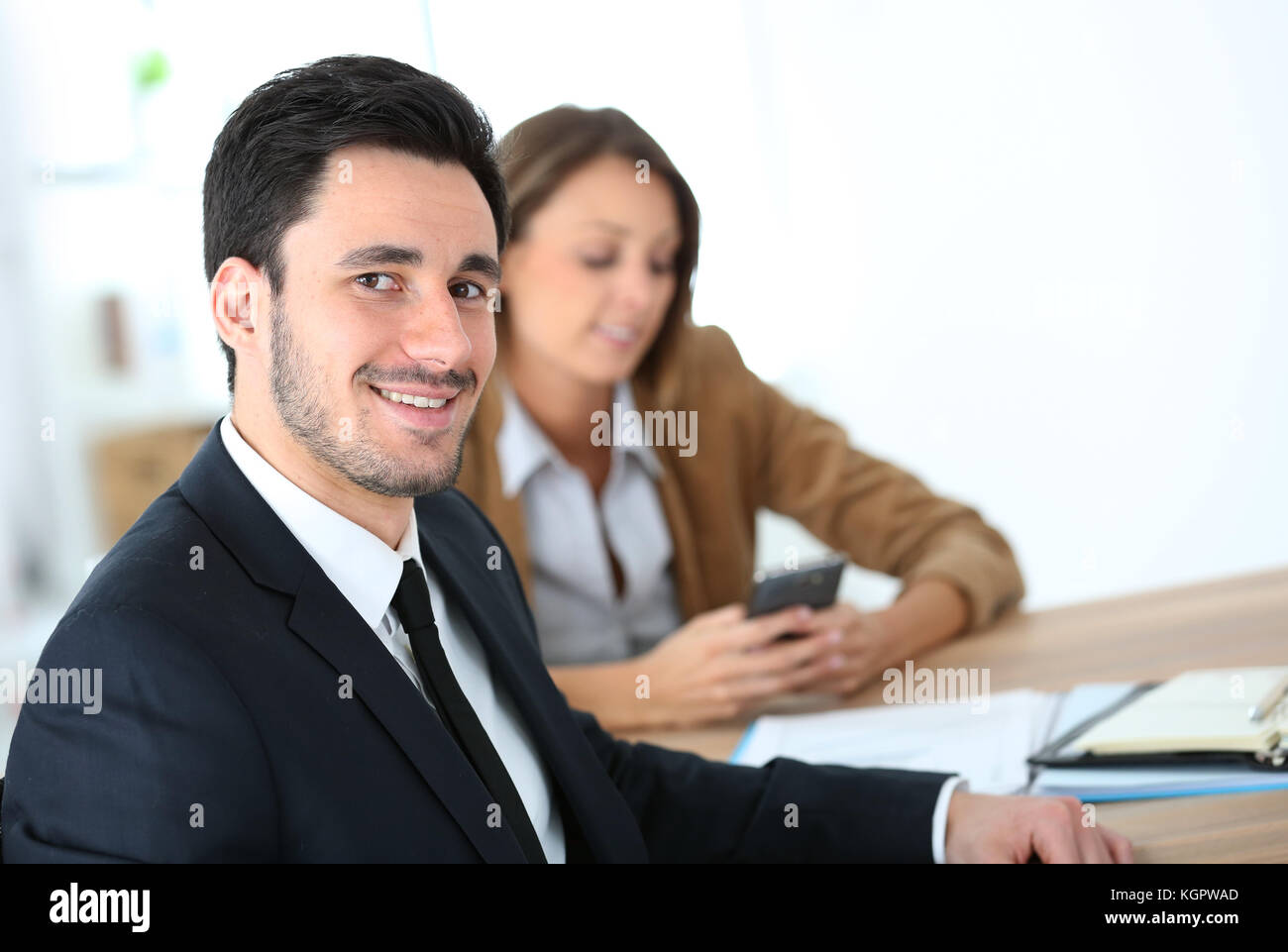 Portrait of smiling businessman having a meeting Stock Photo - Alamy