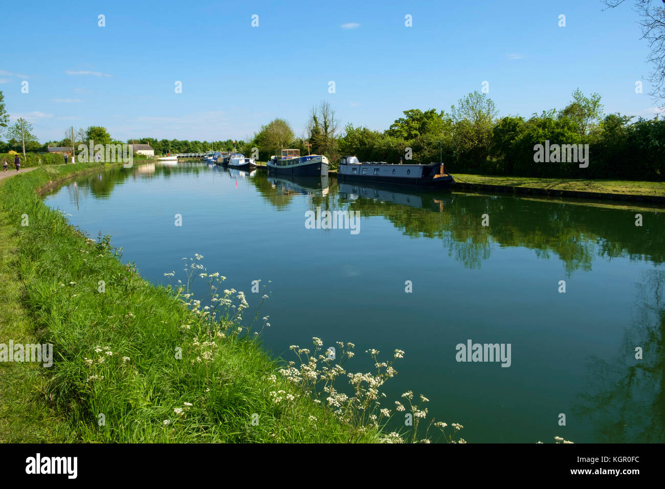 Boat moorings and people walking the towpath of the tranquil Gloucester
