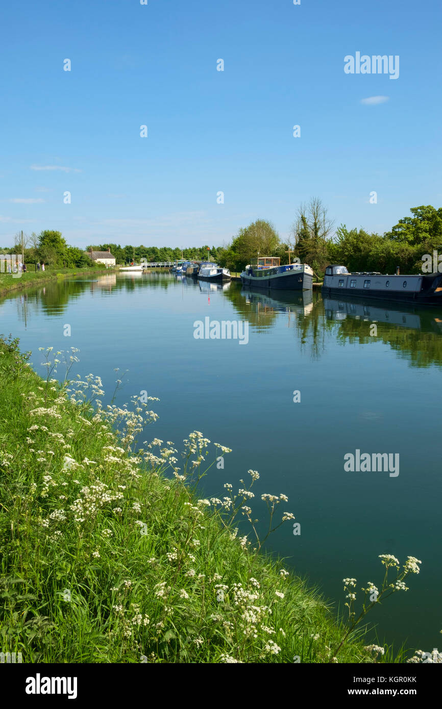 Boat moorings and people walking the towpath of the tranquil Gloucester