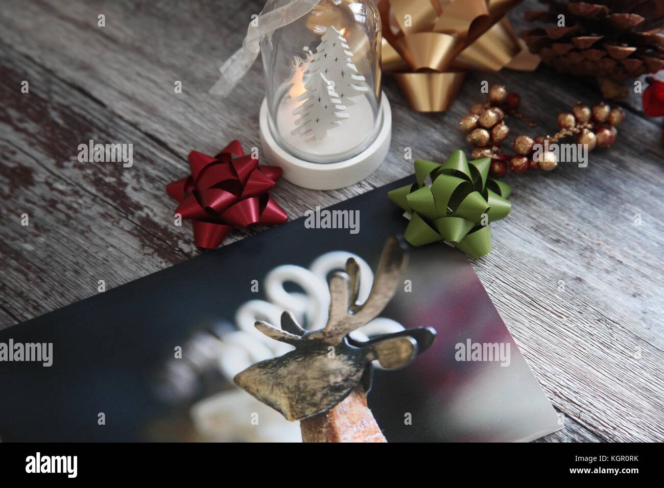 Still life with christmas card, tree decorations and bows Stock Photo