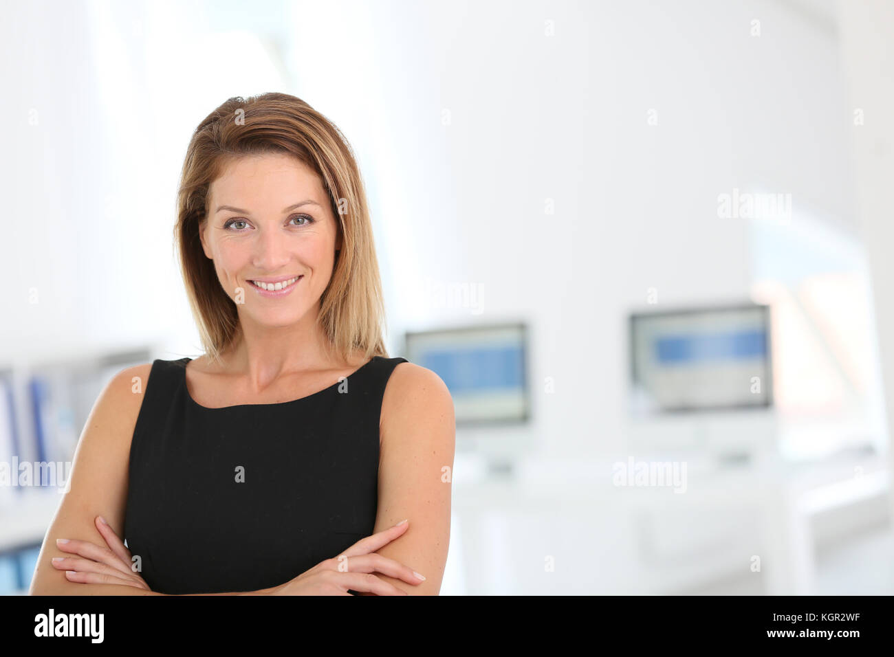 Confident businesswoman standing in office Stock Photo - Alamy