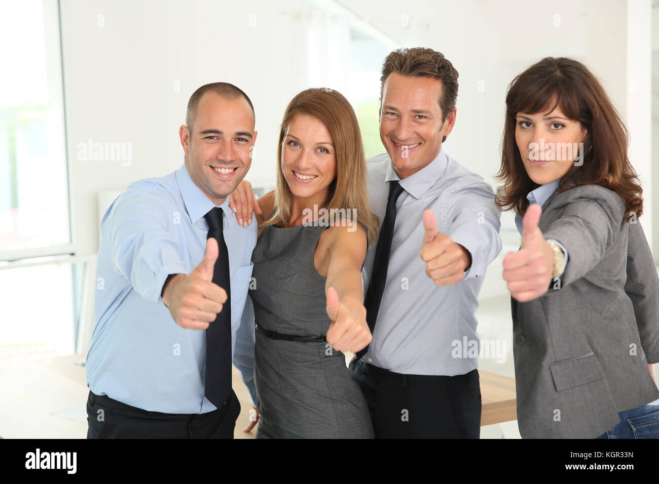 Successful business team showing thumbs up Stock Photo - Alamy