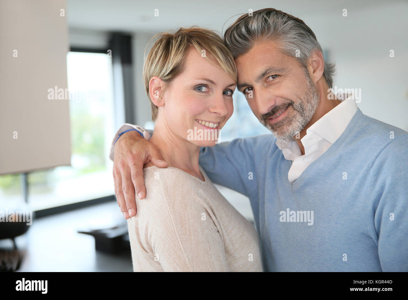 Smiling middle-aged couple standing in brand new home Stock Photo - Alamy