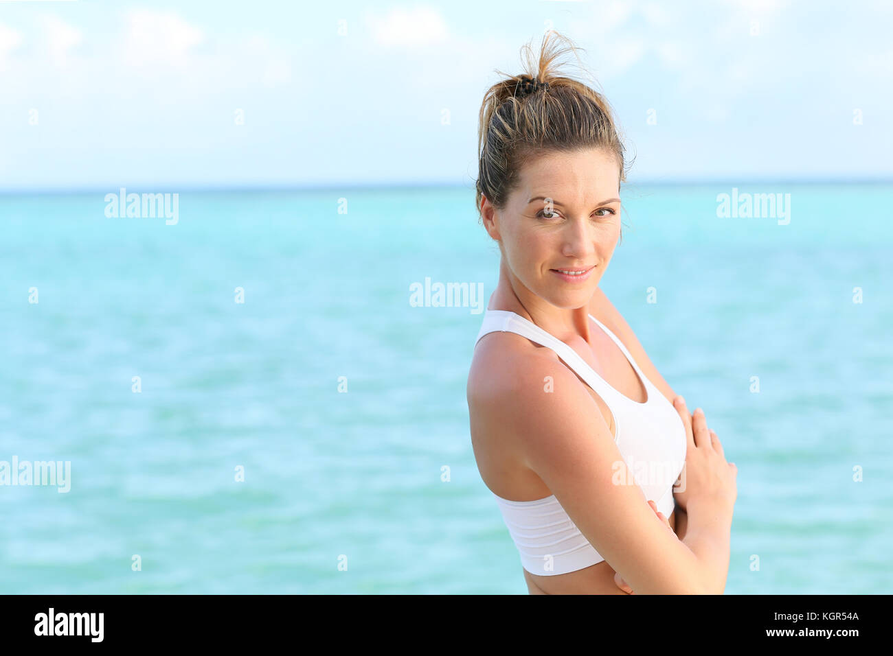 Portrait of beautiful fitness girl standing by the sea Stock Photo - Alamy